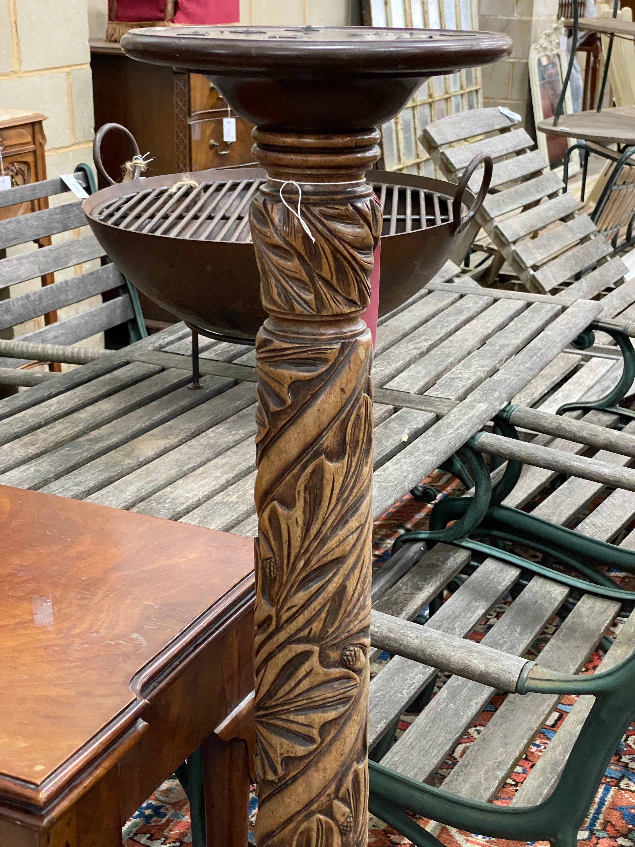 A Victorian style carved mahogany torchere, (formerly a bedpost)